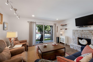 Living room with wood finished floors, a fireplac