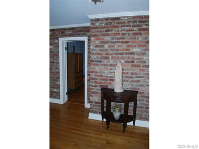 Spacious foyer with exposed brick, hardwood floors