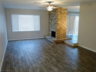 Living room has a ceiling fan and a  stone, 2 way,