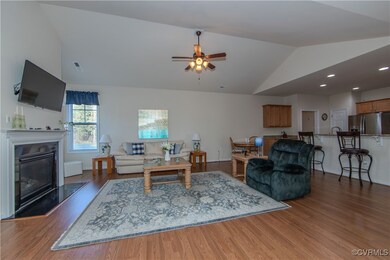 Living room featuring dark hardwood / wood-style flooring, lofted ceiling, and ceiling fan