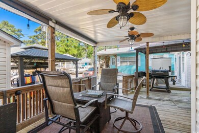 Wooden terrace featuring a gazebo and a ceiling fan