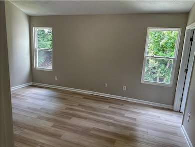 Empty room featuring light wood-style flooring and a textured ceiling