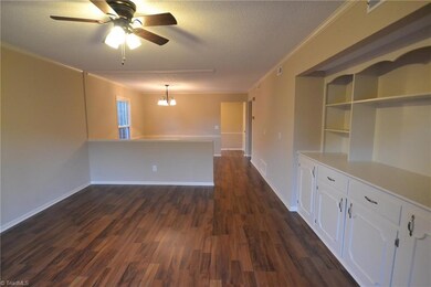 Living room with built in shelving, looking toward dining room