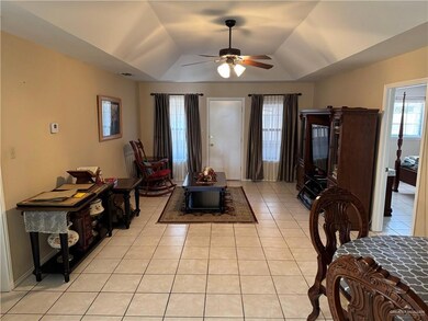Entryway featuring light tile patterned flooring, a ceiling fan, and a tray ceiling