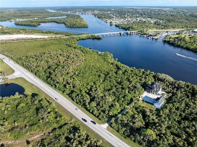 Aerial view of property and surrounding area with a nearby body of water and a notable bridge