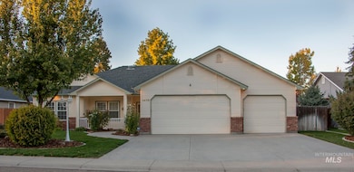 View of front facade with brick siding, covered porch, driveway, and an attached garage