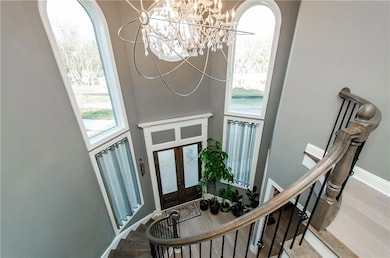 Foyer entrance featuring a chandelier, wood finished floors, stairway, french doors, and a high ceiling