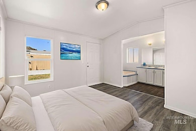 Bedroom featuring dark wood finished floors and lofted ceiling