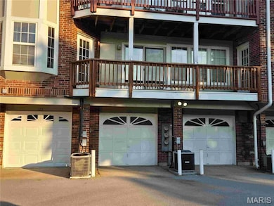Rear view of house with a balcony and brick siding