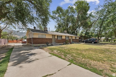 Ranch-style house featuring driveway, brick siding, and a chimney