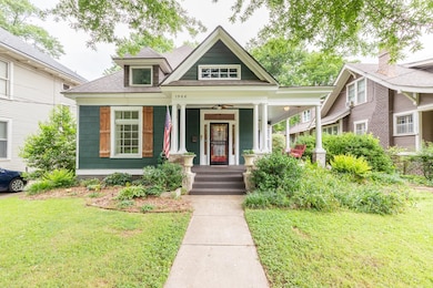 View of front of property with covered porch, a front lawn, and roof with shingles