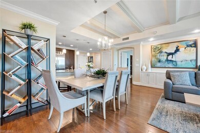 Kitchen featuring kitchen peninsula, appliances with stainless steel finishes, backsplash, light stone countertops, and decorative light fixtures