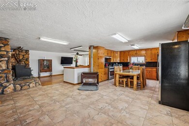 Kitchen featuring a textured ceiling, brown cabine