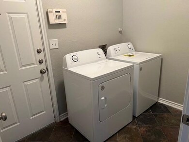 Laundry room featuring washing machine and clothes