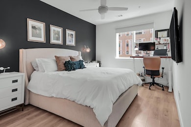 Bedroom featuring an office area, wood finished floors, and a ceiling fan