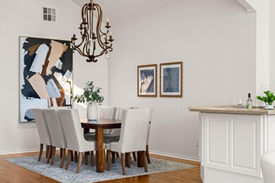 Dining space featuring light wood-type flooring, a chandelier, and lofted ceiling