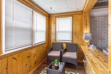 Sitting room with brick wall, wooden walls, and da