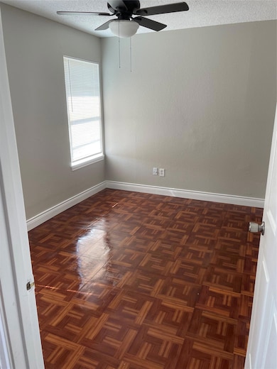 Empty room with a textured ceiling and ceiling fan