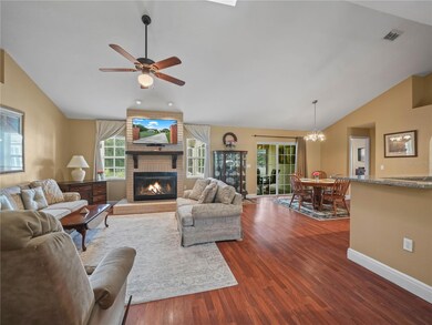 Living Room with wood burning fireplace and skylight