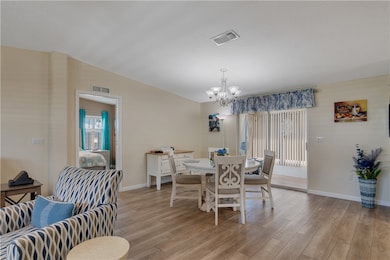 Dining room featuring light wood-type flooring and a chandelier