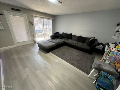Living area featuring a textured ceiling and wood finished floors