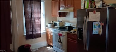 Kitchen featuring stainless steel appliances and wall chimney range hood