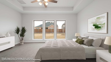 Carpeted bedroom featuring a ceiling fan, a raised