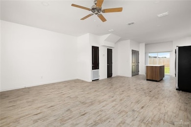 Unfurnished living room with light wood-style flooring and a ceiling fan
