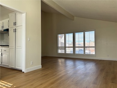 Unfurnished living room featuring lofted ceiling w