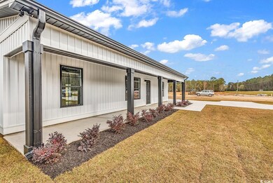 View of side of home featuring a porch and a lawn