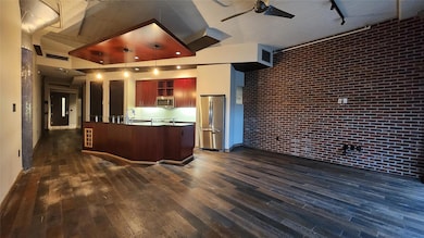 Kitchen featuring brick wall, track lighting, dark