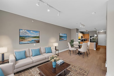 Living room with rail lighting and light wood-type flooring