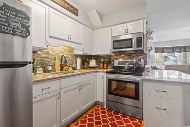 Kitchen featuring white cabinets, decorative backs