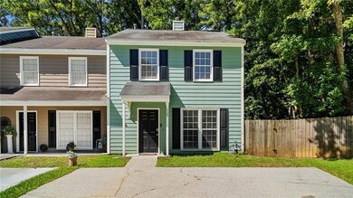 View of front of house featuring a chimney, a shingled roof, and a porch