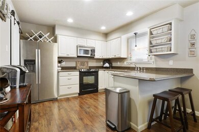 Kitchen has white cabinets, granite counter tops a