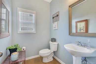 Half bathroom has neutral gray paint, beautiful fl
