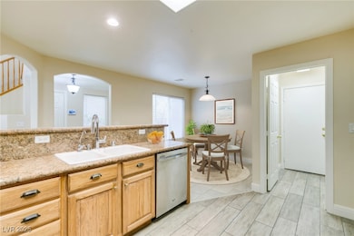 Kitchen with dishwasher, a sink, arched walkways,