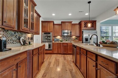 The gourmet kitchen features upgraded cabinets, st