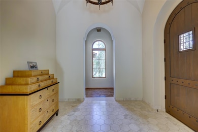 Entryway with light tile patterned floors and arc