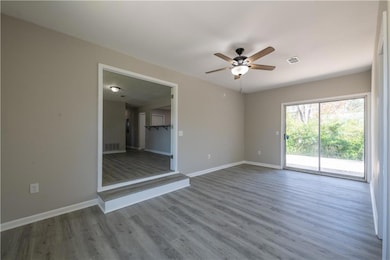 Spare room featuring baseboards, ceiling fan, visible vents, and wood finished floors