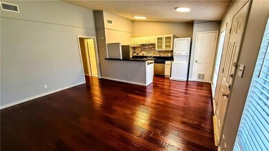 Kitchen with glass insert cabinets, tasteful backsplash, dark countertops, vaulted ceiling, and a textured ceiling