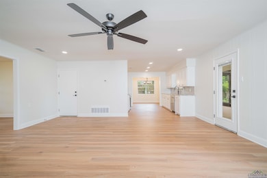 Unfurnished living room with plenty of natural light, light wood-type flooring, ceiling fan, and recessed lighting