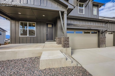 View of exterior entry featuring board and batten siding, a garage, stone siding, concrete driveway, and a porch