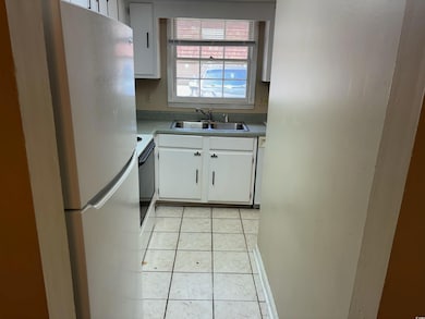 Kitchen with sink, white cabinetry, white applianc