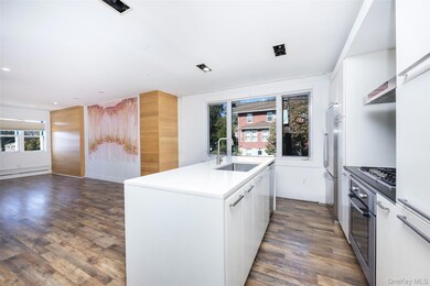Kitchen featuring white cabinetry, a center island with sink, dark wood-style flooring, open floor plan, and recessed lighting