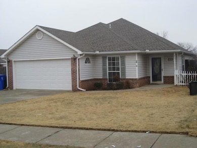Ranch-style house with a garage, driveway, brick siding, and a shingled roof