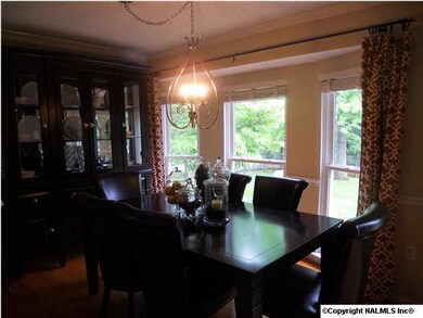The dining room also features hardwood flooring and crown molding.