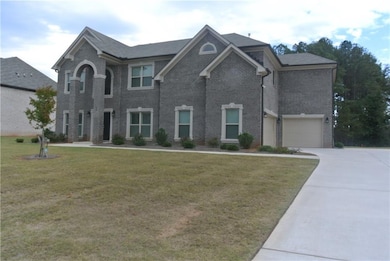 View of front lawn, driveway, and an attached garage