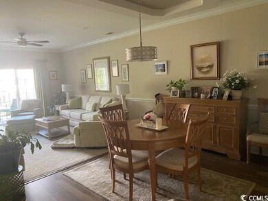 Dining room with a ceiling fan, crown molding, and wood finished floors