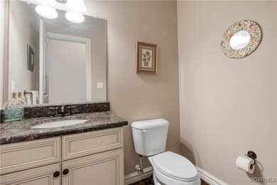 Bathroom with toilet, vanity, and baseboards